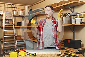 Beautiful caucasian young woman working in carpentry workshop at table place photo