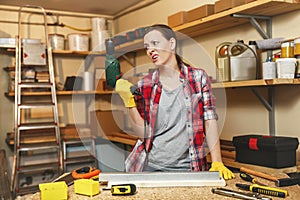 Beautiful caucasian young woman working in carpentry workshop at table place photo