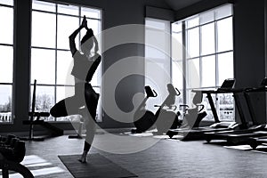 Beautiful caucasion white woman doing yoga exercises in fitness gym