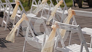 Beautiful chairs with ribbons at the wedding reception.