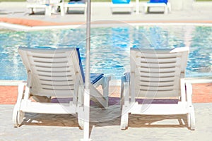 Beautiful chaise lounges by the pool on nature at sea background