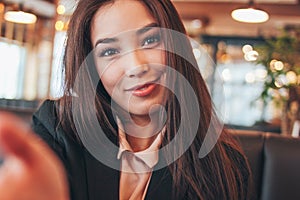 Beautiful charming brunette happy asian girl young woman giving handshake, hand of help, greeting at cafe