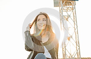 Beautiful charming brunette long hair happy asian girl in black leather jacket at sunset