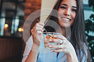 Beautiful charming brunette smiling Asian girl has Breakfast with coffee and Chia pudding at cafe