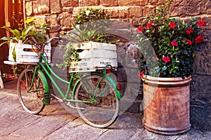 Beautiful charming street landscape with an old bike with flowers in boxes in the middle of an ancient street on a cobblestone