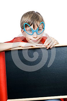 Beautiful cheerful child dressed as superman holds a rectangular black board