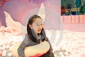 Beautiful cheerful little girl playing pleasure ground on playground