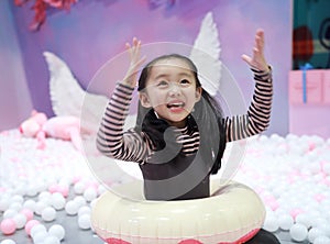 Beautiful cheerful little girl playing pleasure ground on playground