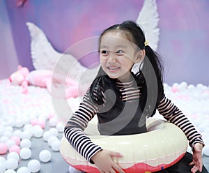 Beautiful cheerful little girl playing pleasure ground on playground