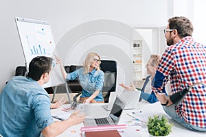 Beautiful cheerful woman pointing at the whiteboard