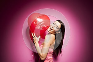 Beautiful cheerful woman with valentines day balloon