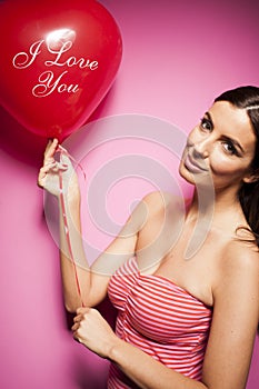 Beautiful cheerful woman with valentines day balloon