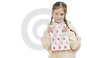 Beautiful cheerful young girl with colored shopping bag in hands over white background, copyspace for your text