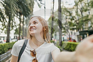 Beautiful cheerful young woman having a good time on the beach on a beautiful day, taking a selfie in Valencia, Spain