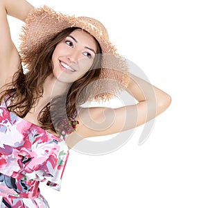 Beautiful cheerful young woman in summer sarafan and straw hat o