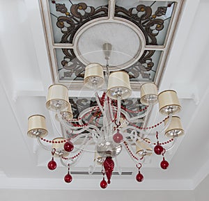 Beautiful large chandelier weighs in the background of a beautiful ceiling