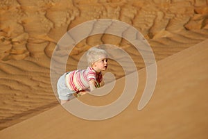 Child climbing sand dune