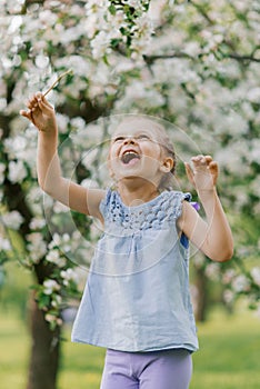 Beautiful child with dandelion flower. Happy kid having fun outdoors in spring park