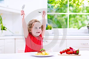 Beautiful child eating pasta