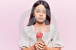 Beautiful child girl holding ice cream thinking attitude and sober expression looking self confident