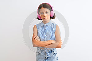 Beautiful child girl listening to music using headphones over isolated white background skeptic and nervous, disapproving