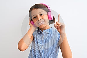 Beautiful child girl listening to music using headphones over isolated white background surprised with an idea or question