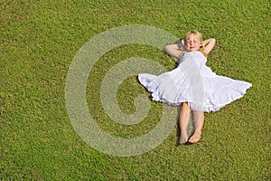 Beautiful Child Girl Lying on the Green Grass, top view