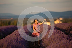 Beautiful child girl runs in the middle of a lavender field