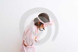 Beautiful child girl wearing sleep mask and pajama standing over isolated white background with hand on stomach because nausea,