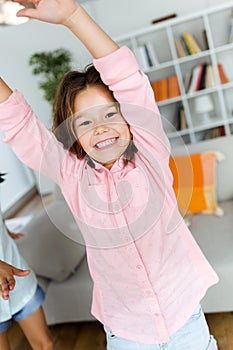 Beautiful child listening to music and dancing at home.