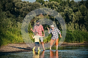 Beautiful child with Parents throws a rock at the river. Skipping Rocks. Three generation family.