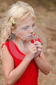 Beautiful child smelling flower