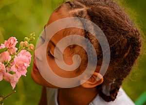 Beautiful child smelling flower