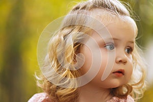 Beautiful child in spring park. Happy kid having fun outdoors. Closeup of pretty cute little girl with long