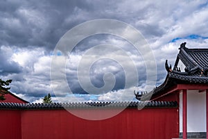 Beautiful chinese architecture. Traditional building with red wall fence and cloudy sky.