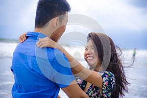 beautiful Chinese Asian couple with woman hug her boyfriend romantic and cuddle on the beach smiling in dating and romance