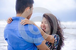 beautiful Chinese Asian couple with woman hug her boyfriend romantic and cuddle on the beach smiling in dating and romance