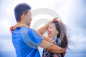 beautiful Chinese Asian couple with woman hug her boyfriend romantic and cuddle on the beach smiling in dating and romance