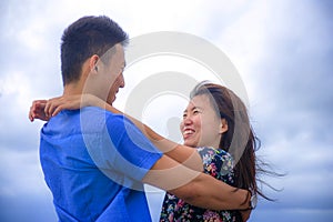 beautiful Chinese Asian couple with woman hug her boyfriend romantic and cuddle on the beach smiling in dating and romance