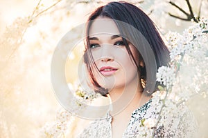 Beautiful Chinese girl among cherry sakura blossoms