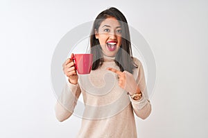 Beautiful chinese woman drinking red cup of coffee standing over isolated white background very happy pointing with hand and