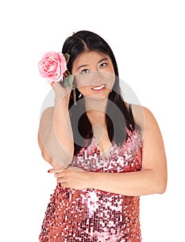 Beautiful Chinese woman holding a pink rose to her hair