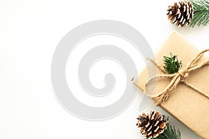 Beautiful Christmas background with gift box, decorate with pine branch and pine cone over white background. Top view with copy sp