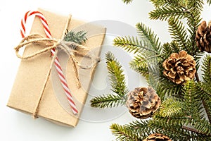 Beautiful Christmas background with gift box, decorate with pine branch and pine cone over white background. Top view, flat lay