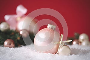 Beautiful Christmas balls on snow against red background