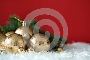 Beautiful Christmas balls on snow against red background. Space for text