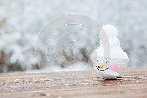 Beautiful Christmas bauble decorations lie on the wooden table over snow covered forest background