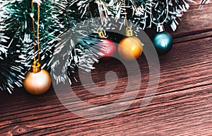 Beautiful Christmas card with a green Christmas tree and frosted balls on a brown wooden background. Christmas tree with small