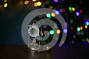 Beautiful Christmas composition of a clock (midnight) on the background of bokeh Christmas tree