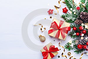 Beautiful Christmas composition on white background with golden Christmas gift boxes, snowy fir branches, conifer cones